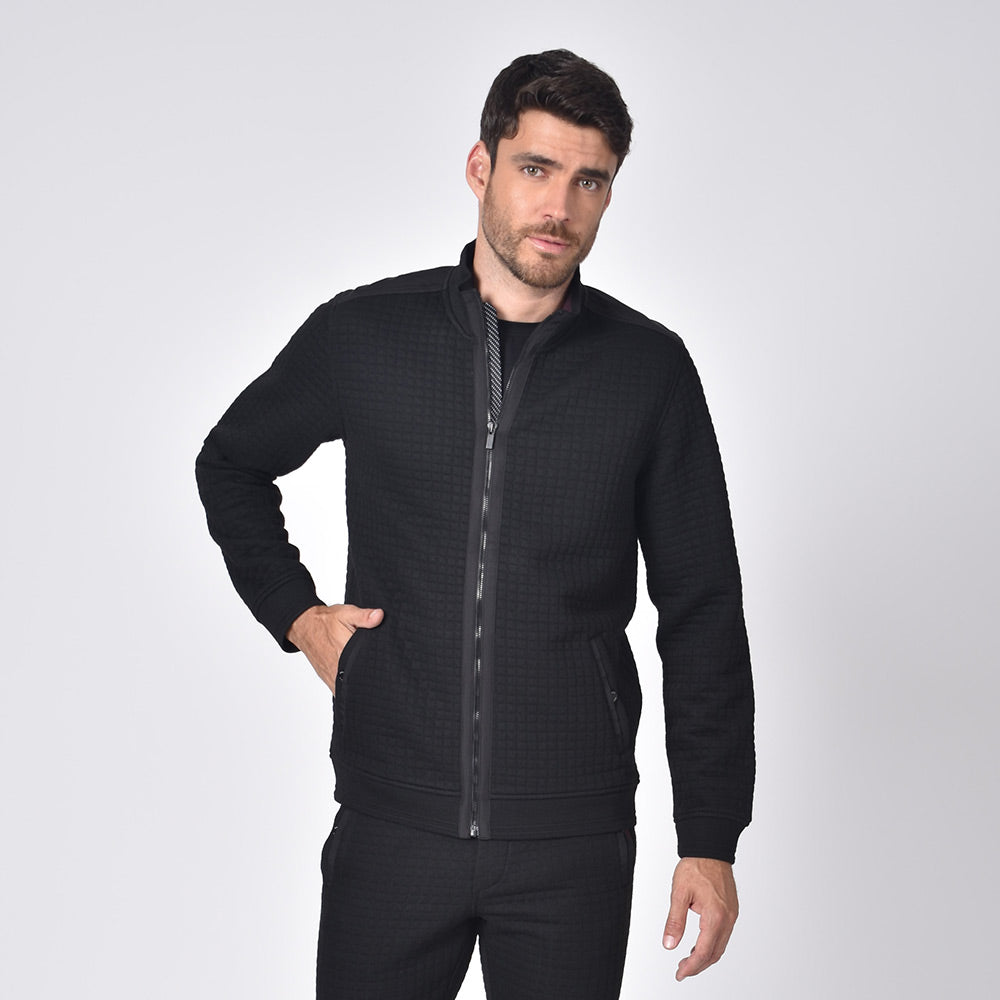 Model in black, quilted track jacket with full front-zipper and front snap-button pockets.