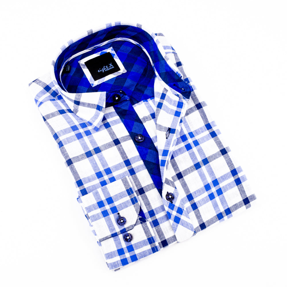 Folded long-sleeve, white linen button-up with navy plaid pattern and blue checkered trim. Includes navy buttons and spread collar. 