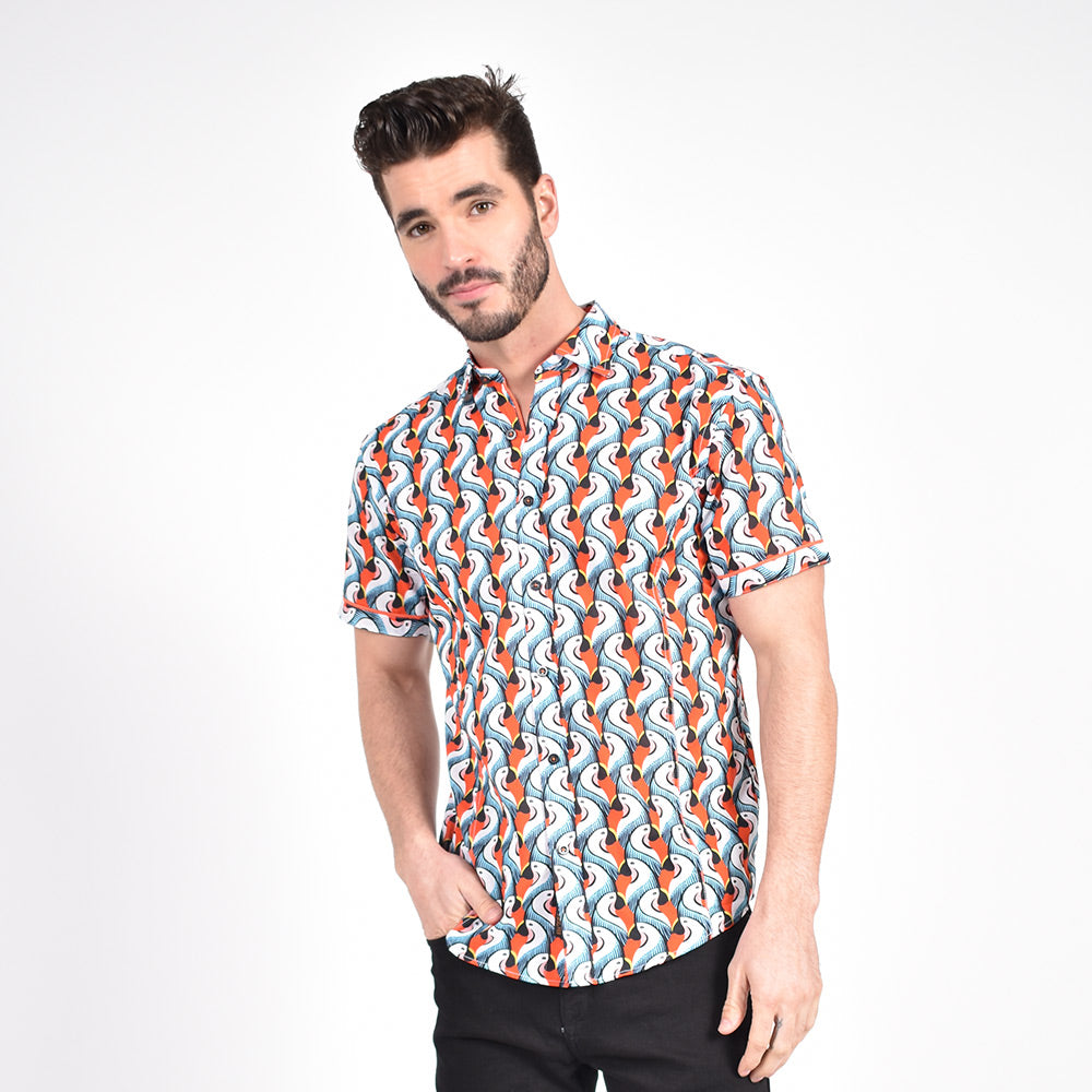 Model in orange short-sleeve button-up with parrot pattern.