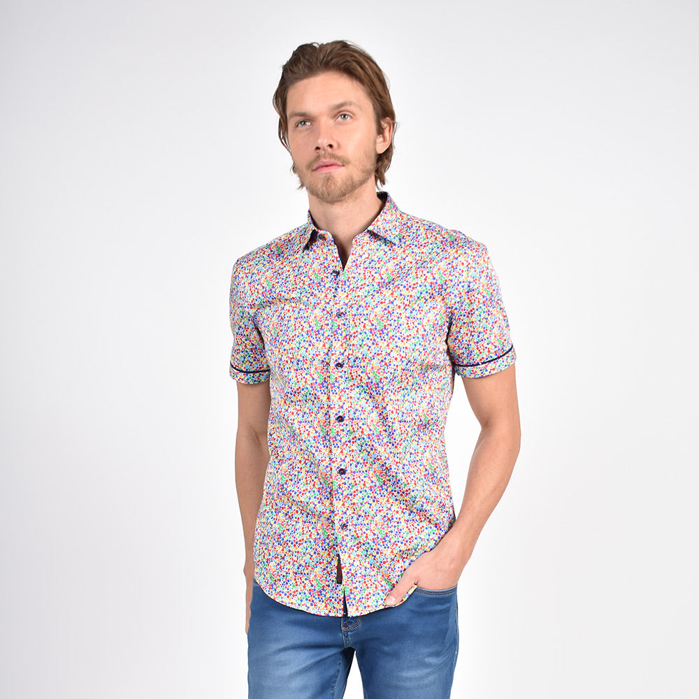 Model in short-sleeve button up with multi-colored confetti print.