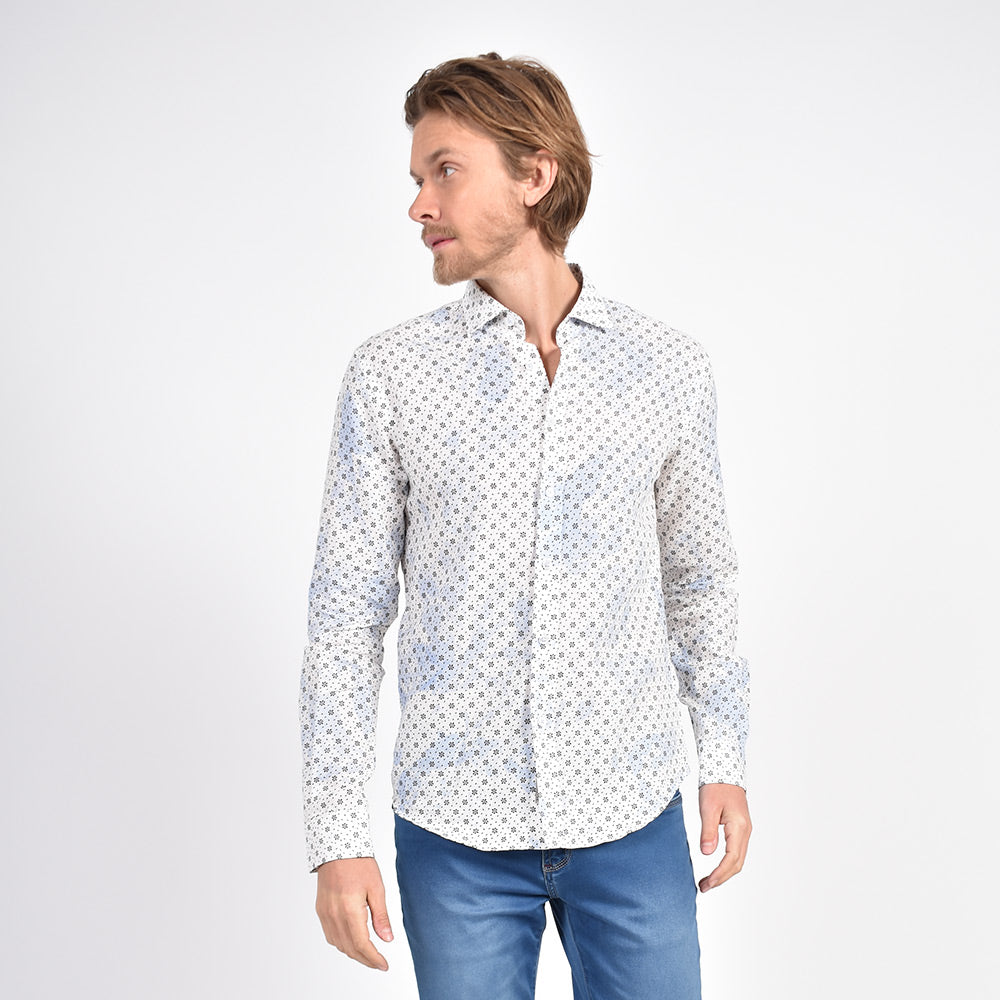Model in long-sleeve, white linen button up with light-blue tie-dye finish and calico print. 