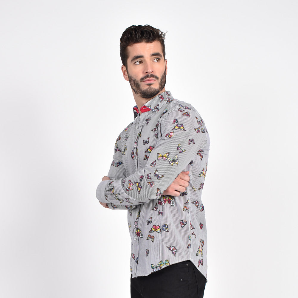 Model in bengal-striped button up with multi-colored butterfly overlay.