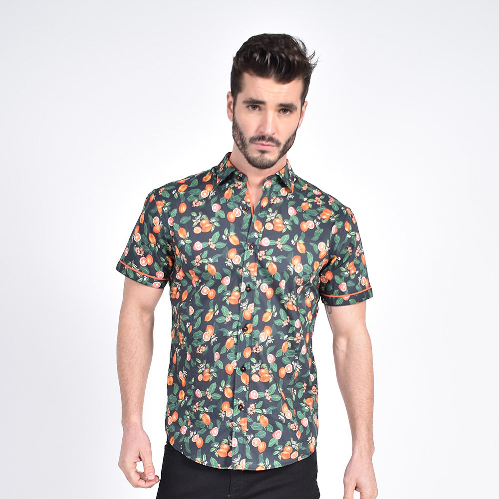 Model in short-sleeve black button-up with citrus print.