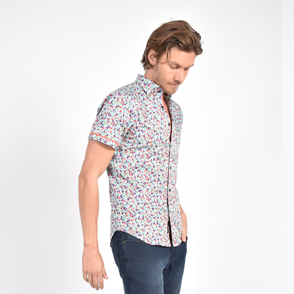 Model in short-sleeve white button-up with small floral print.