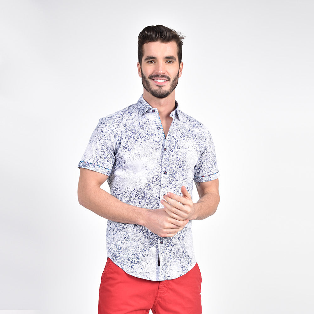 Model in short-sleeve white button-up in faded, navy paisley print. 