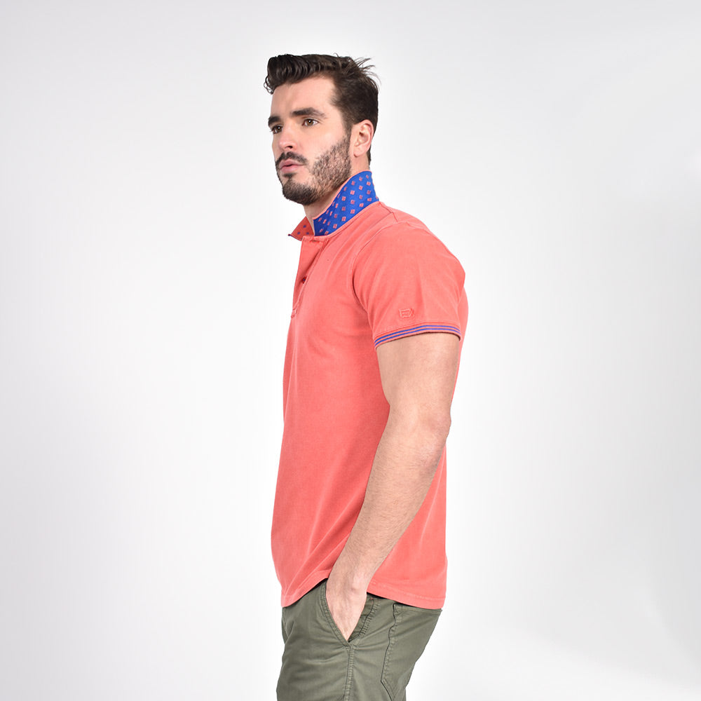Coral jacquard polo with striped, ribbed armbands and reversible diamond grid collar. 
