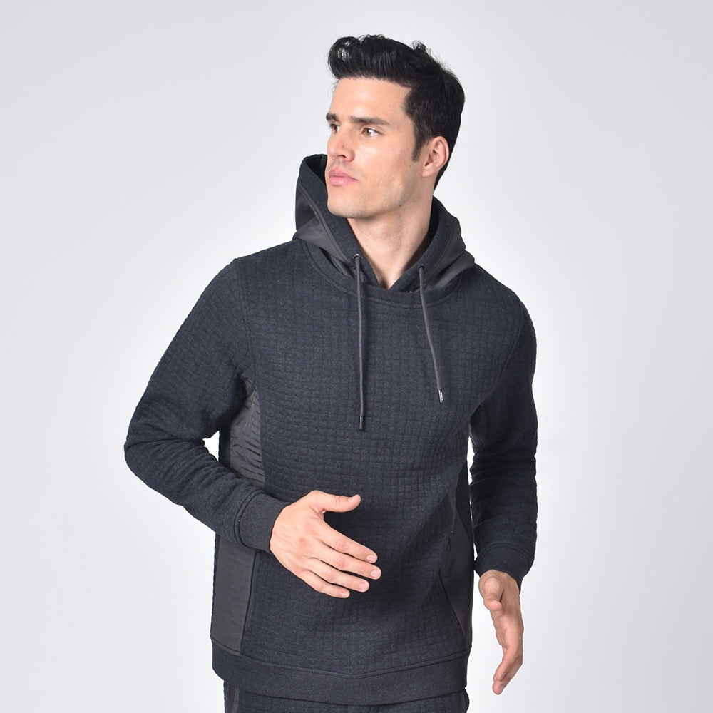 Model in grey, quilted hoodie with side zip-pockets and a drawstring hood.