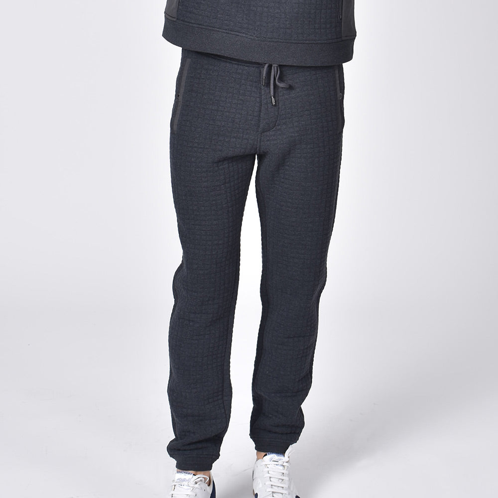Grey, quilted cotton joggers with tapered fit, snap-button pockets, and drawstring waist. 