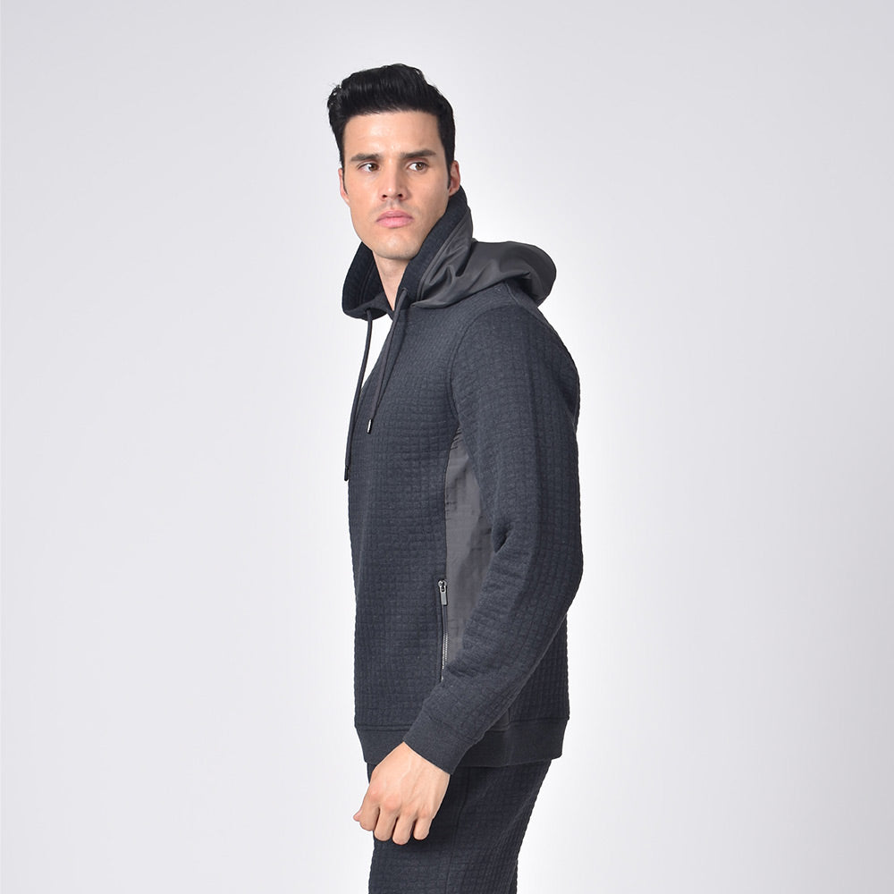 Model in grey, quilted hoodie with side zip-pockets and a drawstring hood.