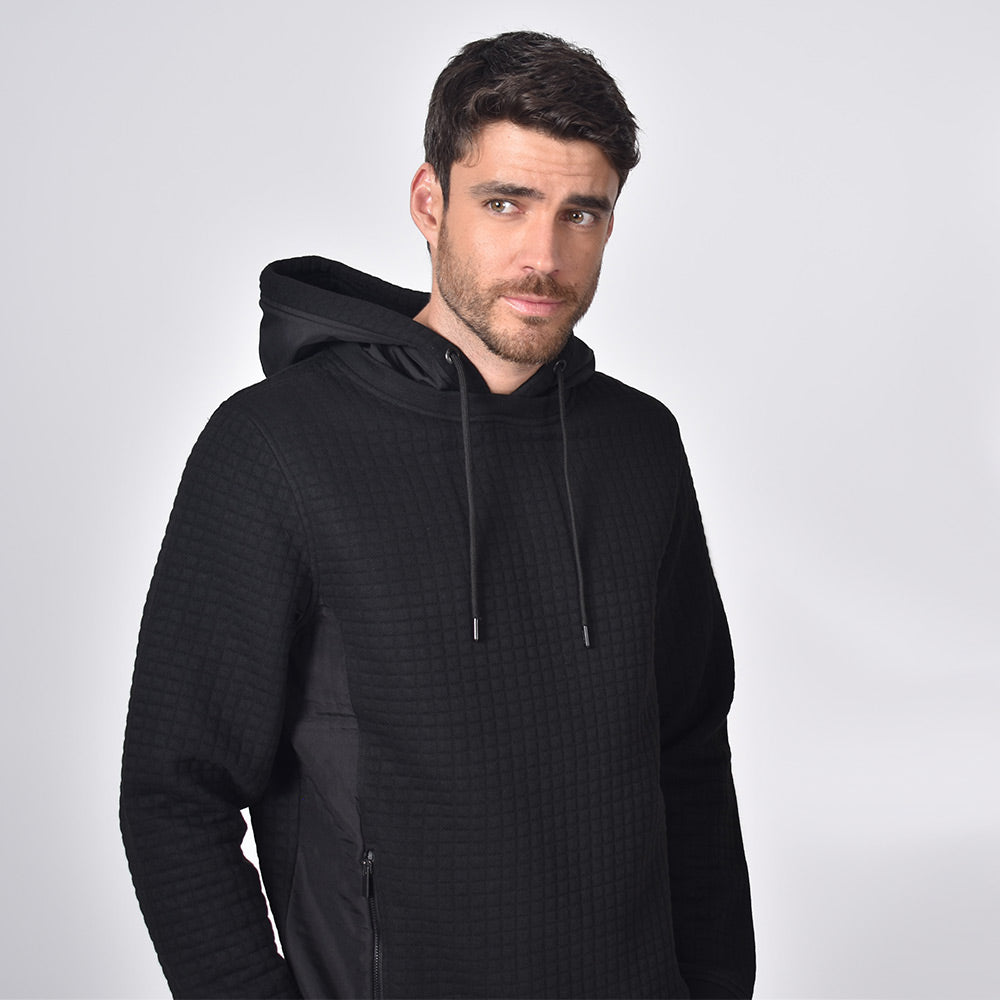 Model in black, quilted hoodie with side zip-pockets and a drawstring hood.