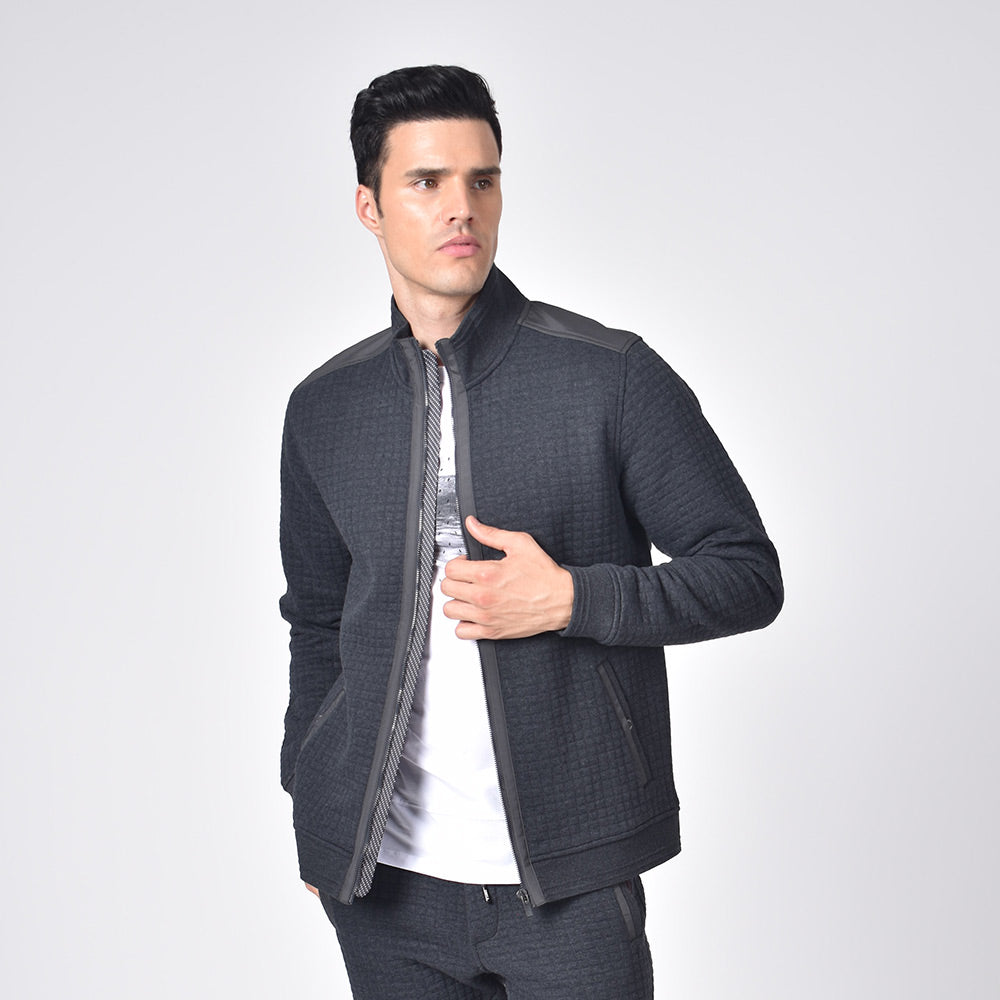 Model in grey, quilted track jacket with full front-zipper and side snap-button pockets.