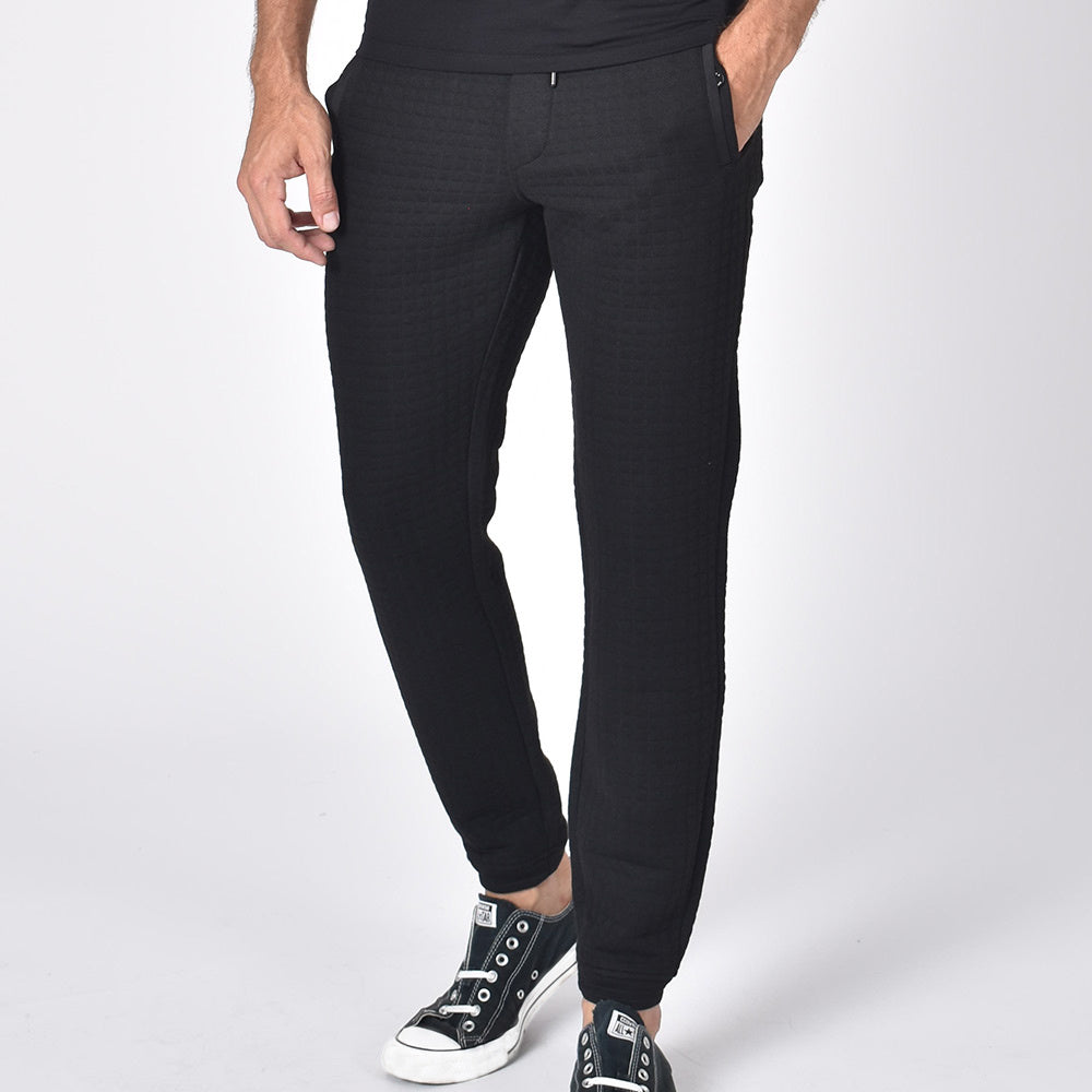 Black, quilted joggers with tapered fit, snap-button pockets, and drawstring waist. 