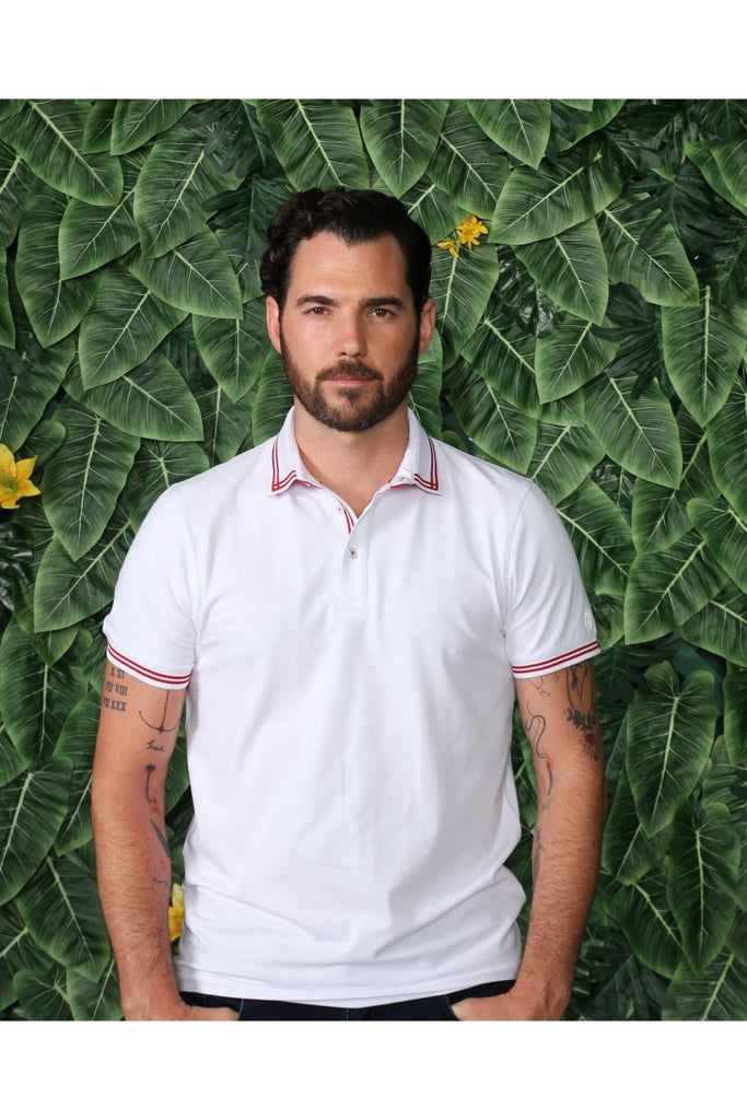 White polo with tipped collar; two-button, red-trimmed placket; and striped, ribbed armbands.
