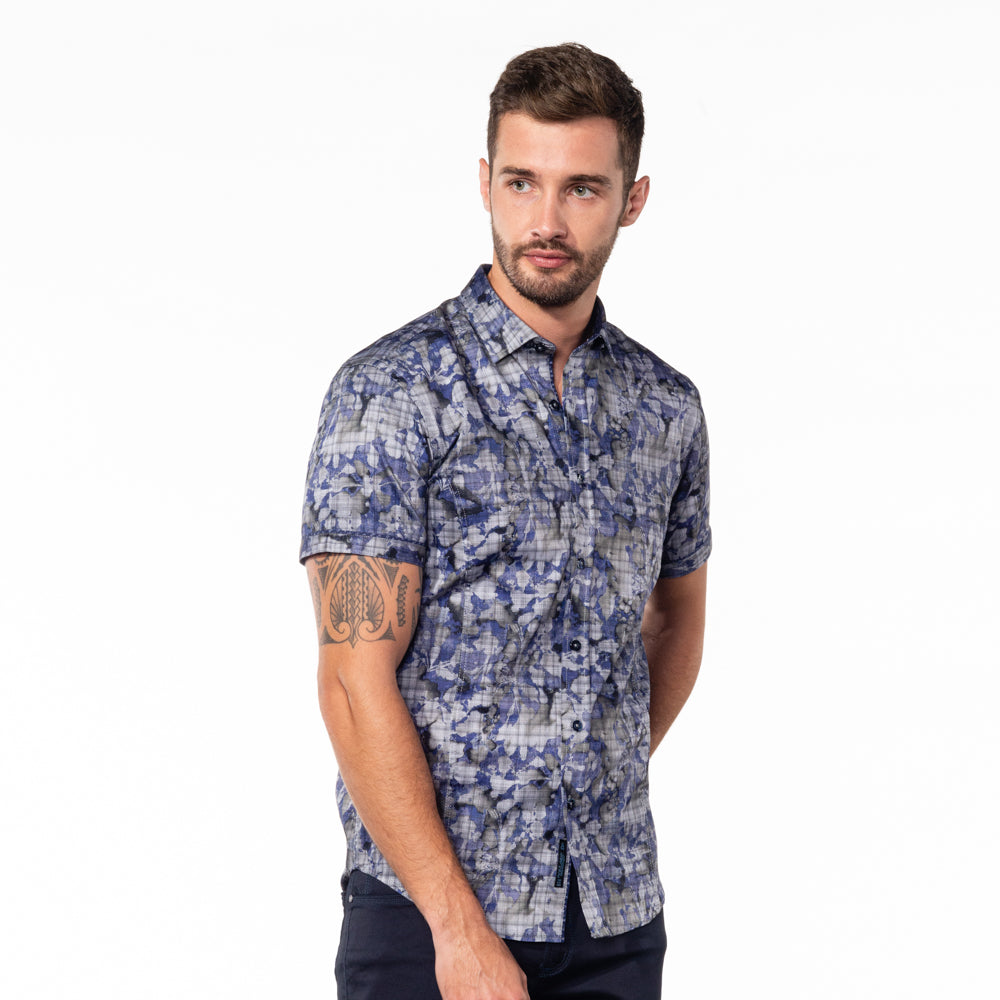Model in button-up with abstract navy and gray digital print design.