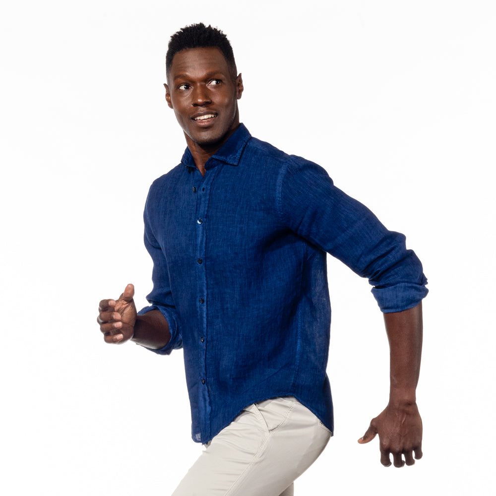 Model in long-sleeve, solid navy-blue linen button-up. 