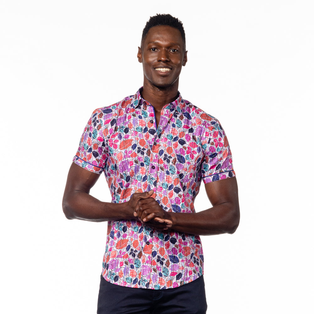Model in short sleeve button up with multicolored foliage print.