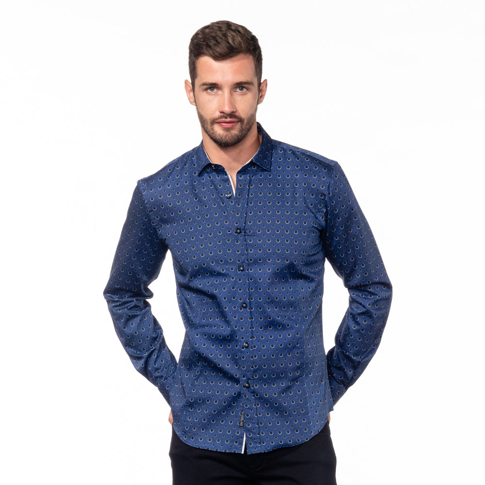 Model in navy-blue button up with black dot print.