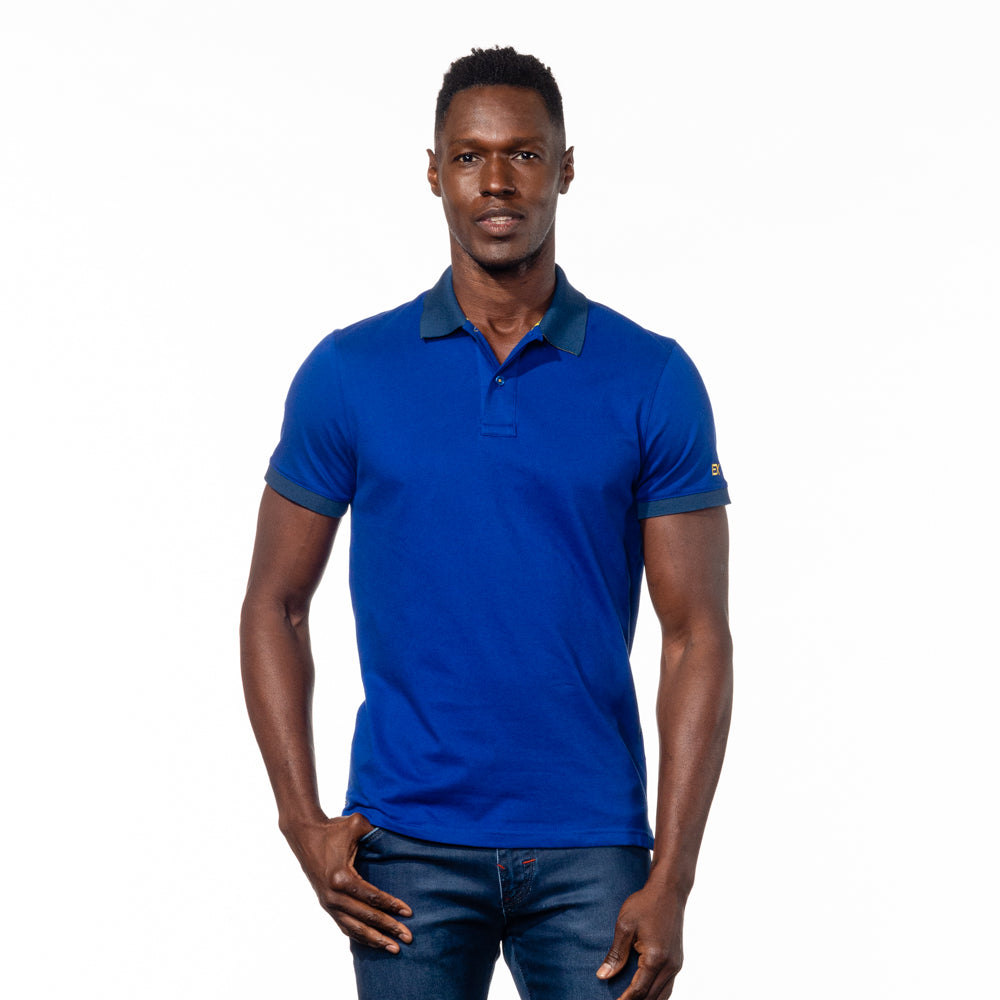 Model in royal-blue polo with navy-blue collar and ribbed armbands.