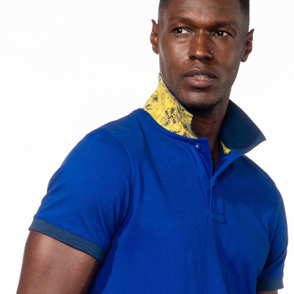 Model in royal-blue polo with reversible paisley-print collar in yellow.