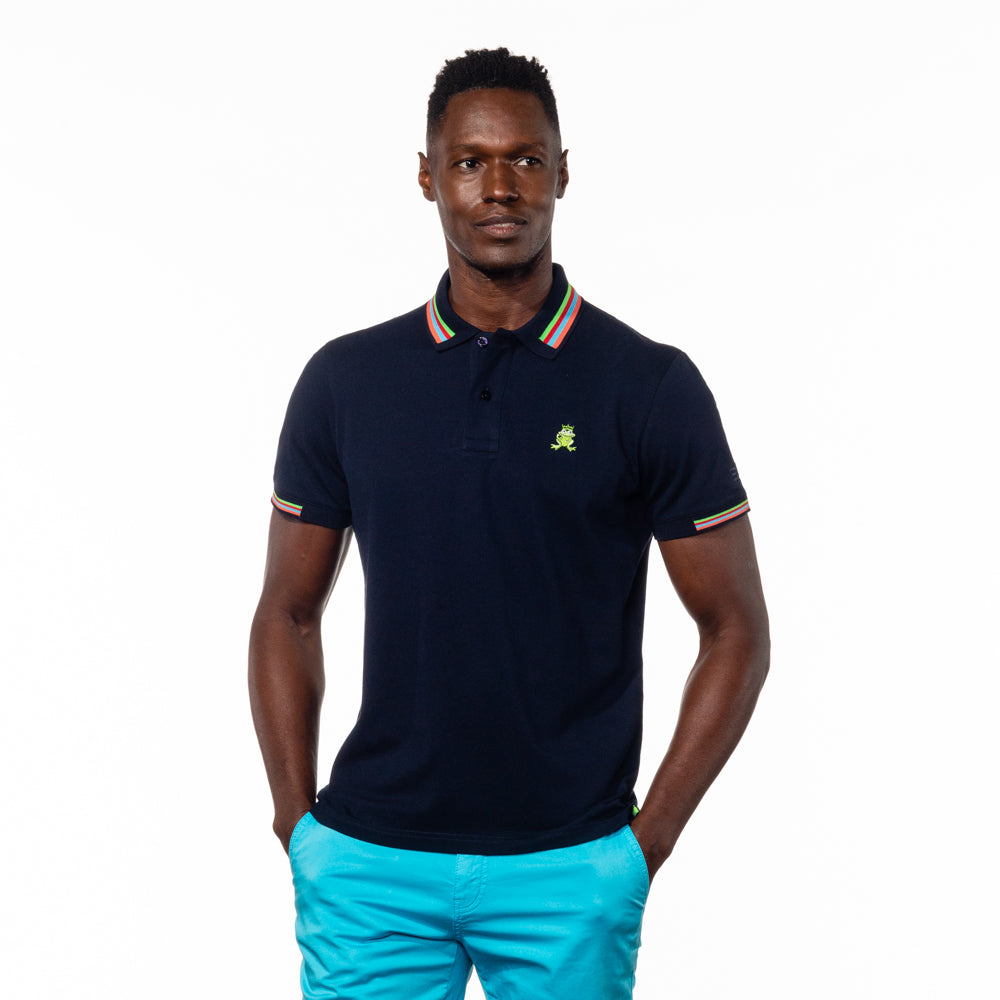 Model wearing navy blue polo with green, red, blue, and peach striped collar, matching ribbed armbands, and embroidered green frog mascot. 