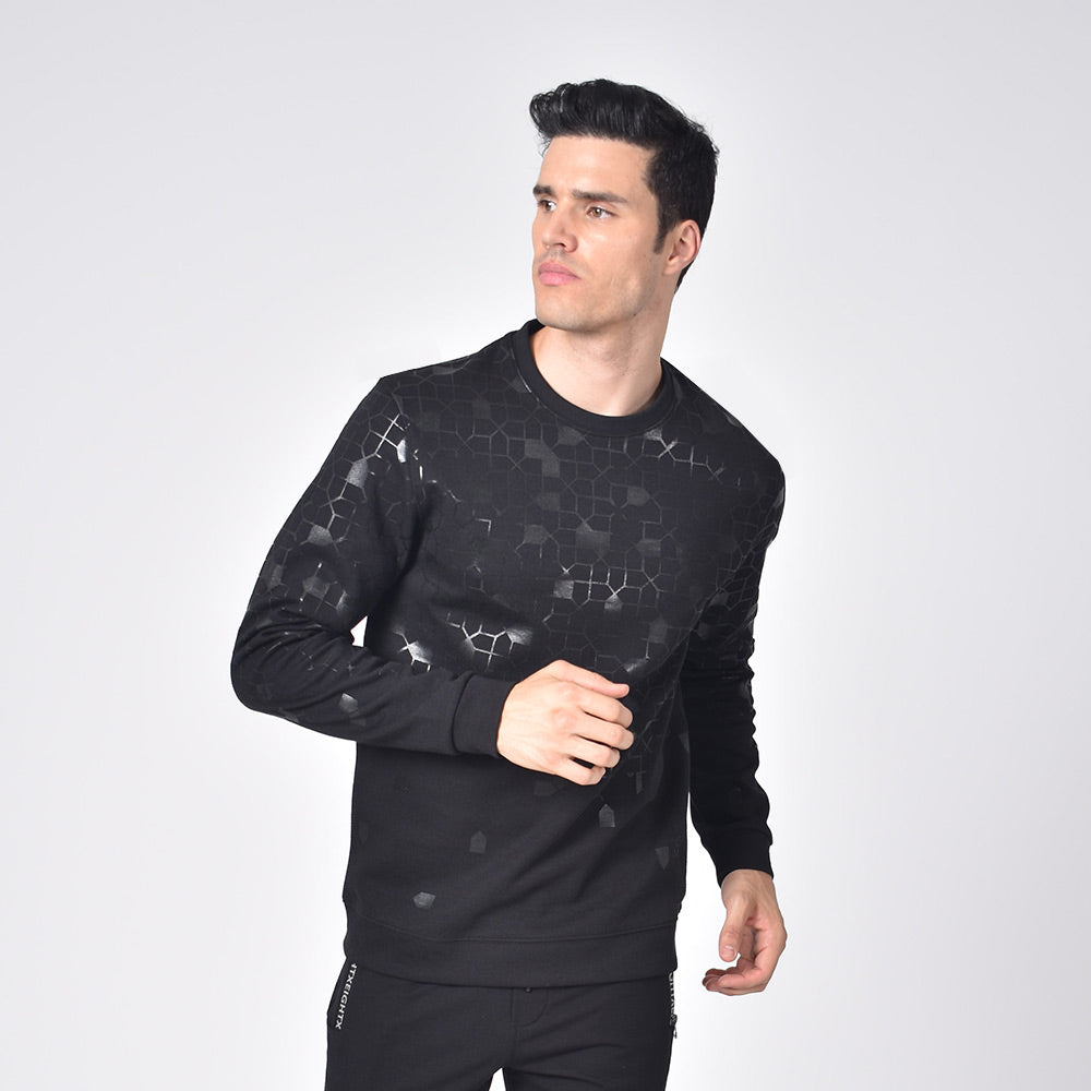 Model in black, long-sleeve, crew-neck sweatshirt with black mosaic design. 
