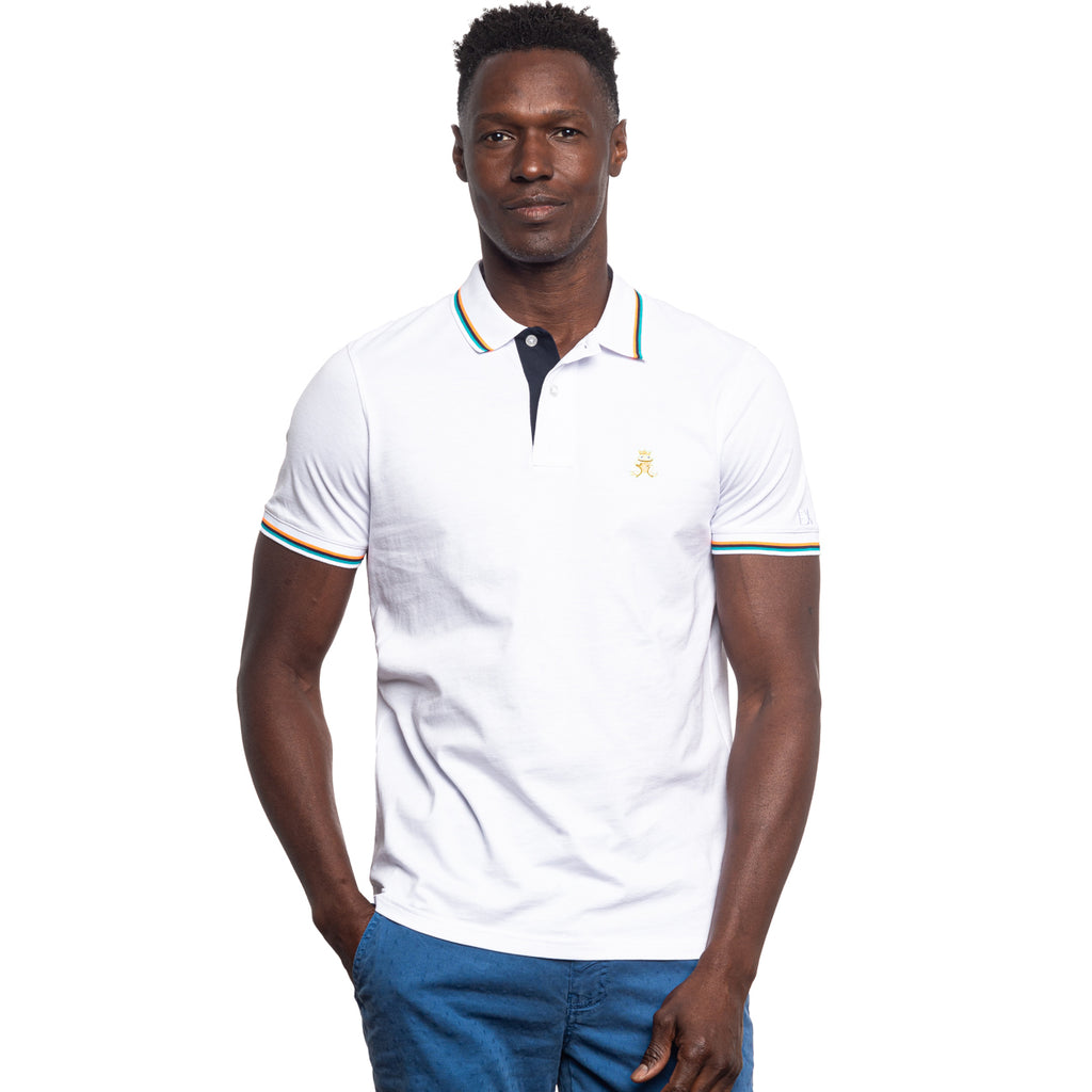 Front view of model wearing a white polo with orange, black, and turquoise striped cuffs and collar. Frog stitched logo on the front.