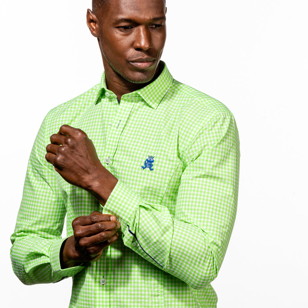 Model buttoning up barrel cuff of bright-green gingham button up with navy trim and royal blue embroidered frog.