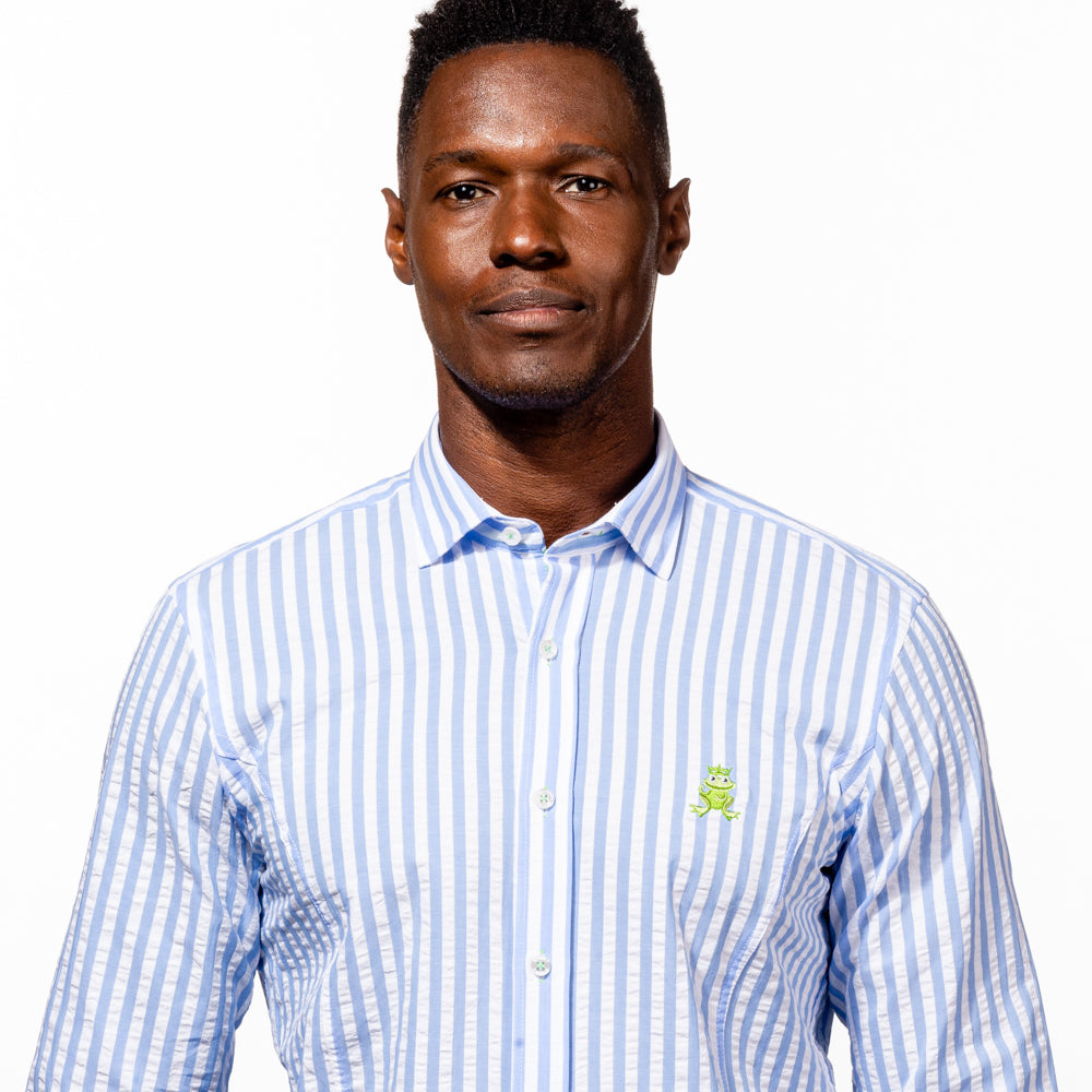 Model in striped, light-blue seersucker button up with green trim, and green, embroidered frog. 