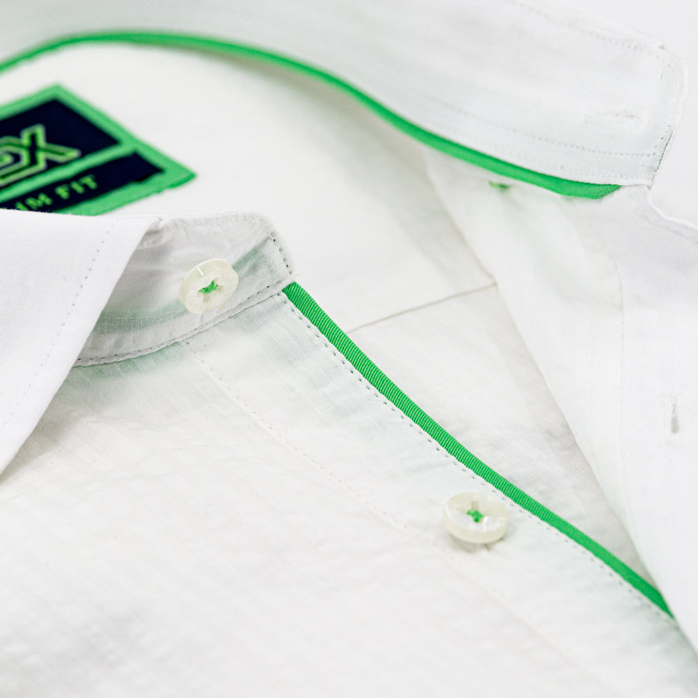 Detail of white seersucker’s collar, green trim, and white buttons.