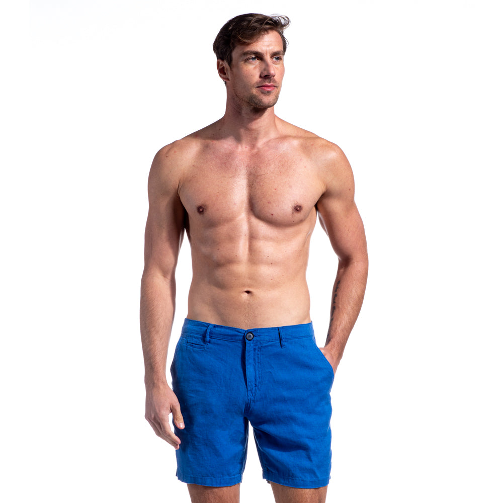 Model in blue linen shorts with two front pockets and one welt pocket.
