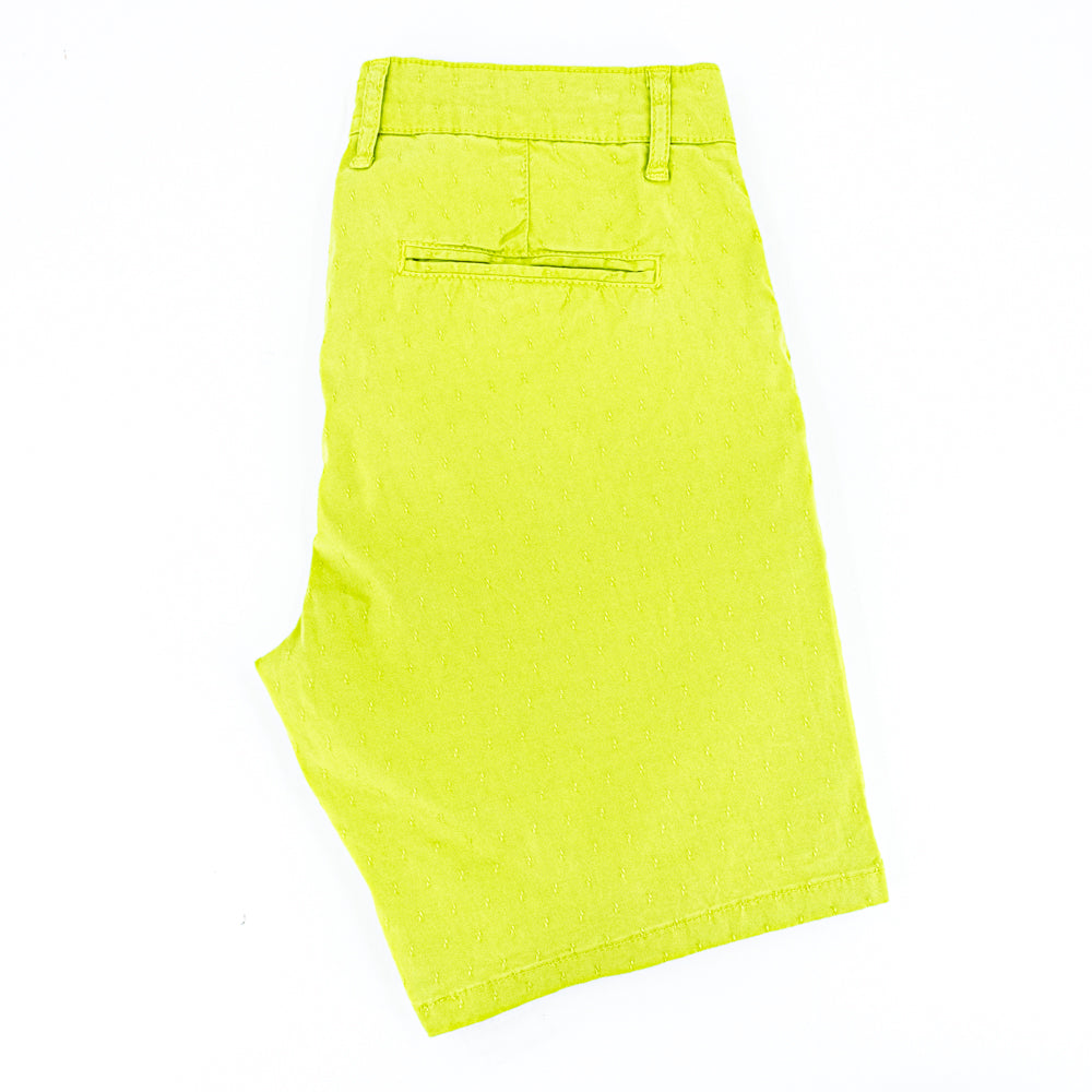 Folded bright-green shorts with back welt pocket.