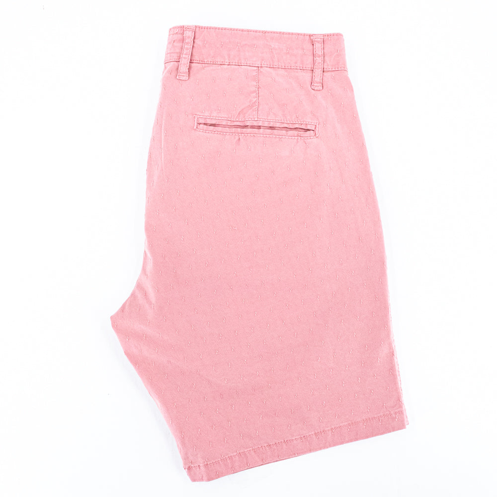 Folded pink shorts with back welt pocket.