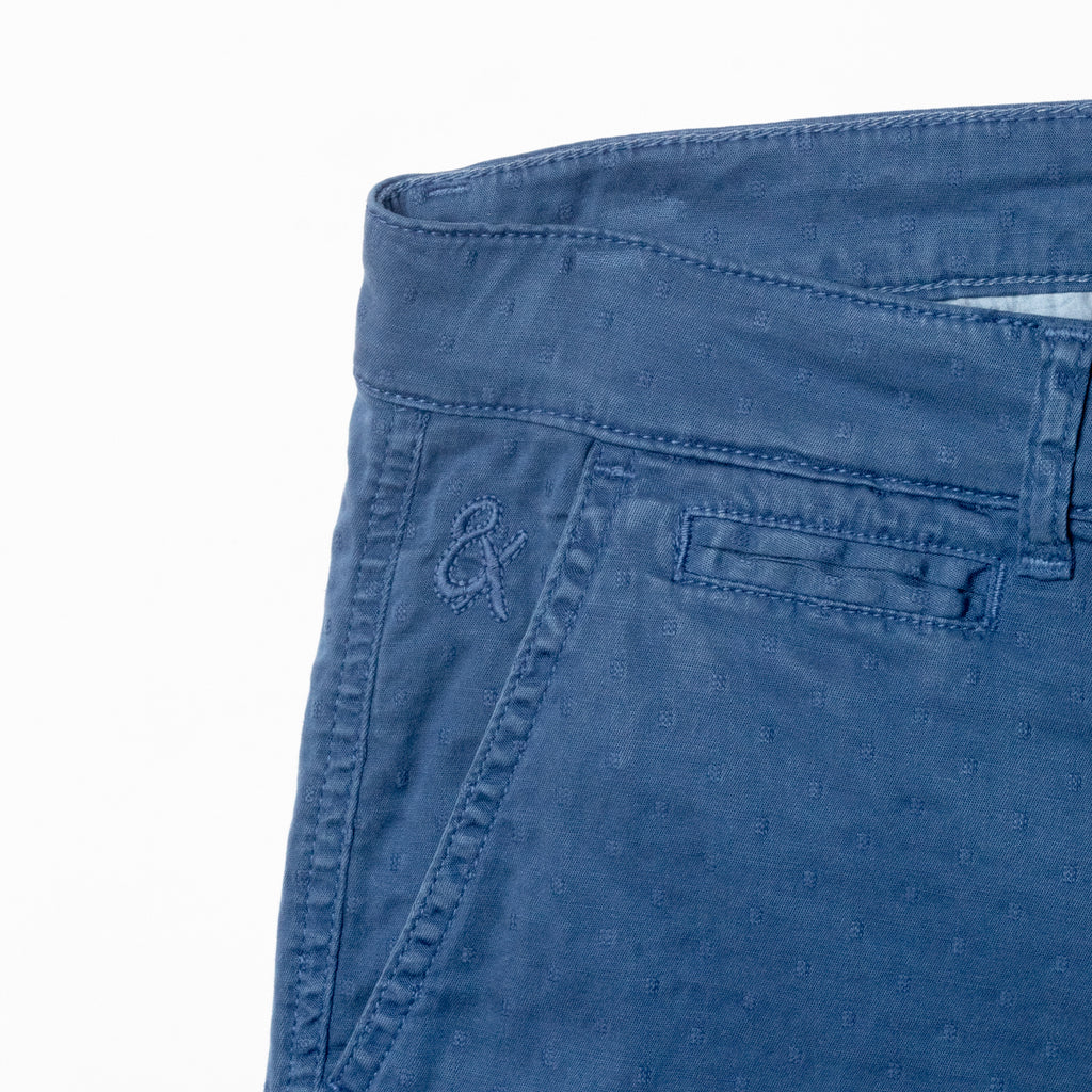 Close-up of blue shorts displaying subtle jacquard texturing and 8x logo embroidery on the right pocket