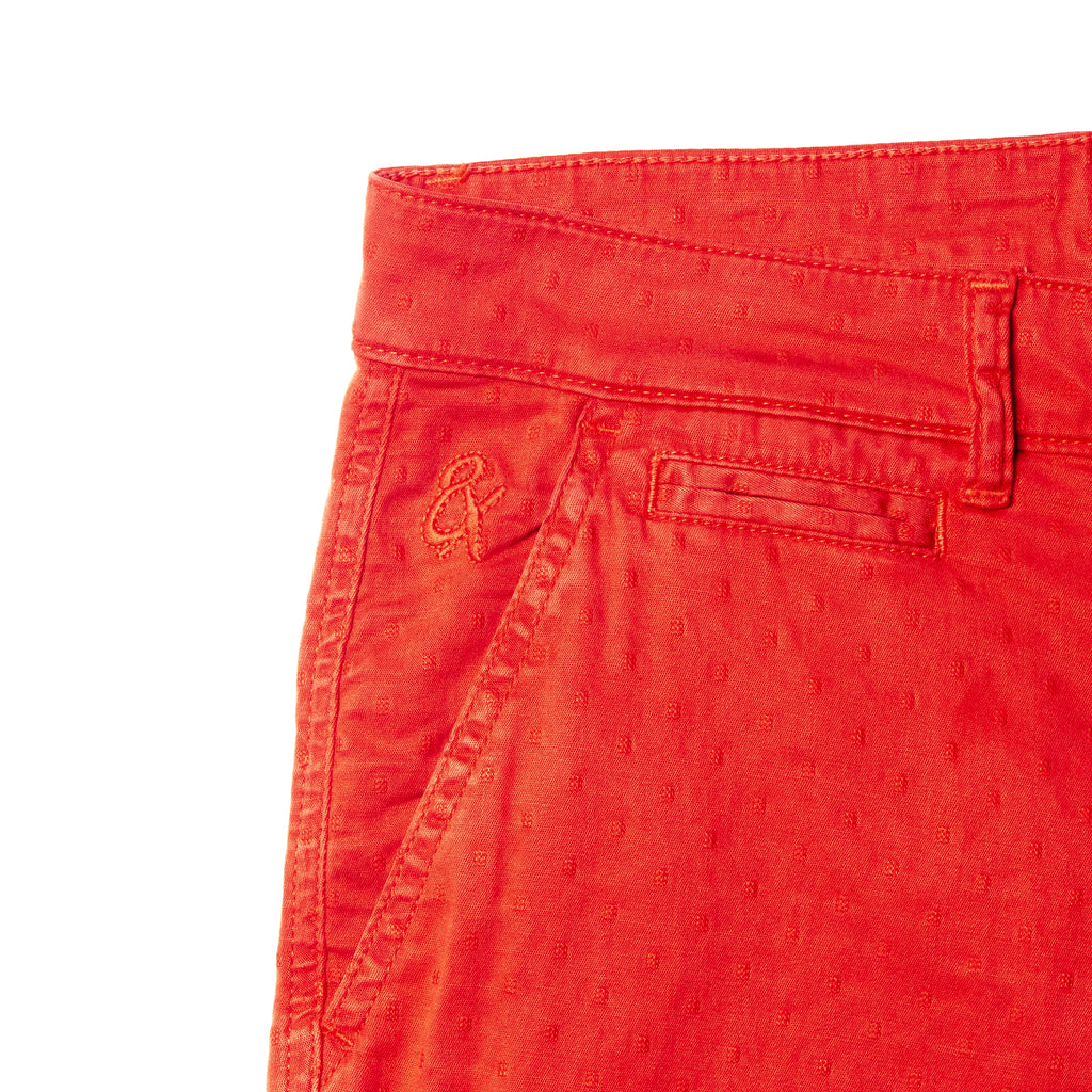 close up on embroidered logo on red jacquard textured shorts