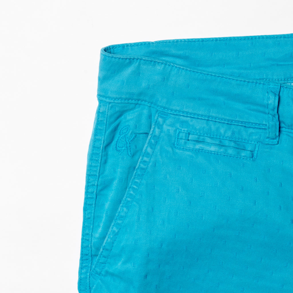 Close-up of turquoise shorts displaying subtle jacquard texturing and 8x logo embroidery on the right pocket