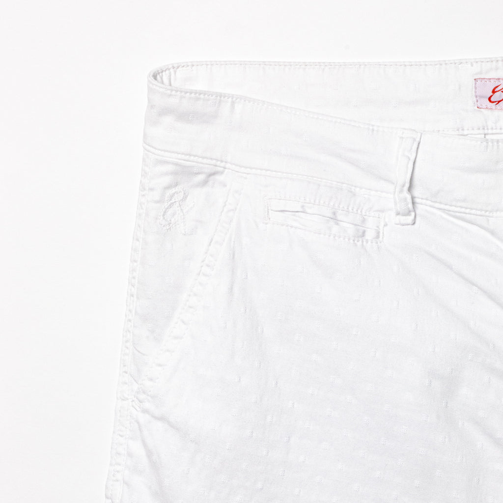 Close-up of white shorts displaying subtle jacquard texturing and 8x logo embroidery on the right pocket