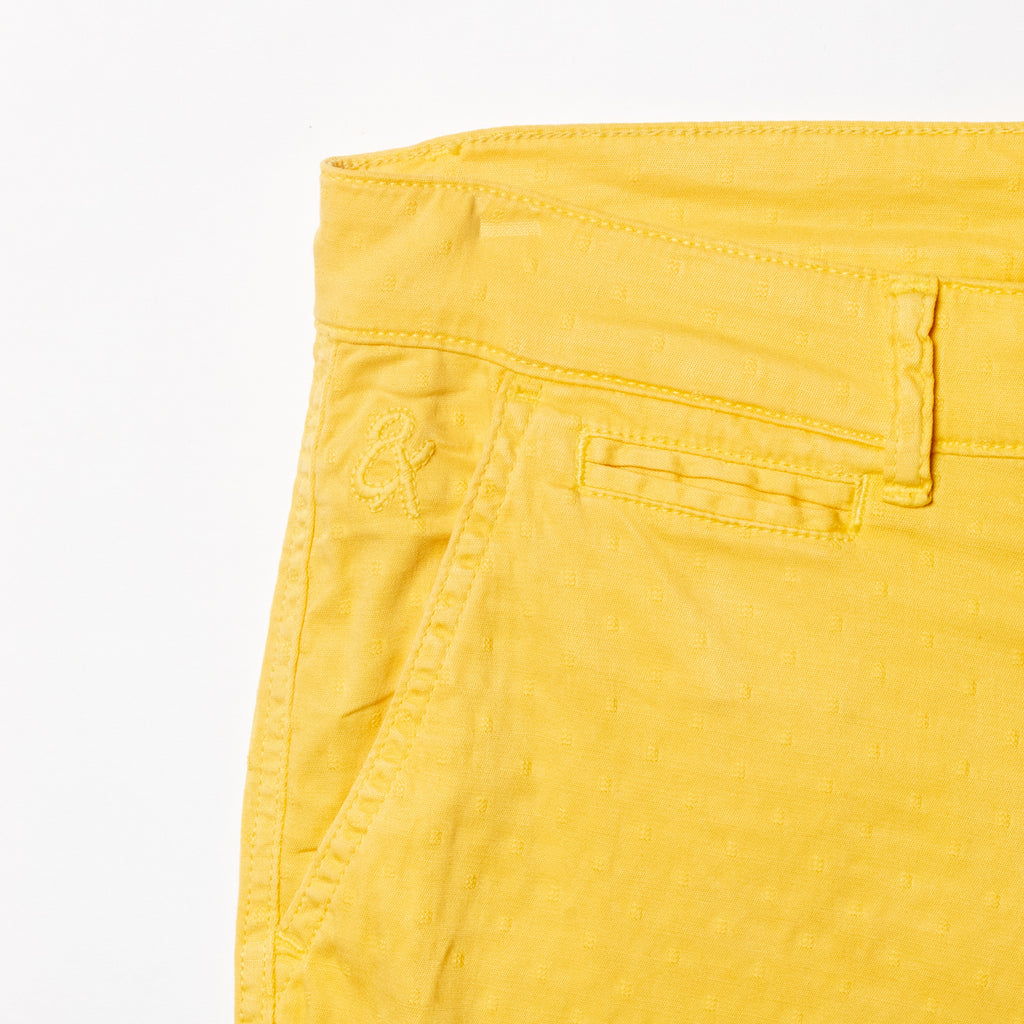 Close-up of yellow shorts displaying subtle jacquard texturing and 8x logo embroidery on the right pocket