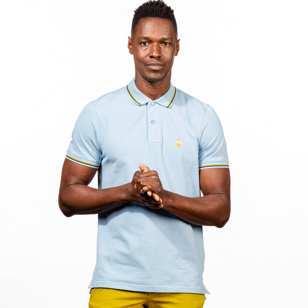 Model in light-blue polo with tipped collar, two-button placket, and striped, ribbed armbands. Featuring embroidered gold frog mascot.