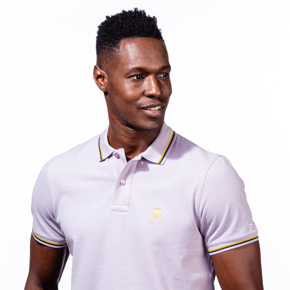 Model in lilac polo with tipped collar, two-button placket, and striped, ribbed armbands. Featuring embroidered gold frog mascot and embroidered EX Logo on left sleeve.