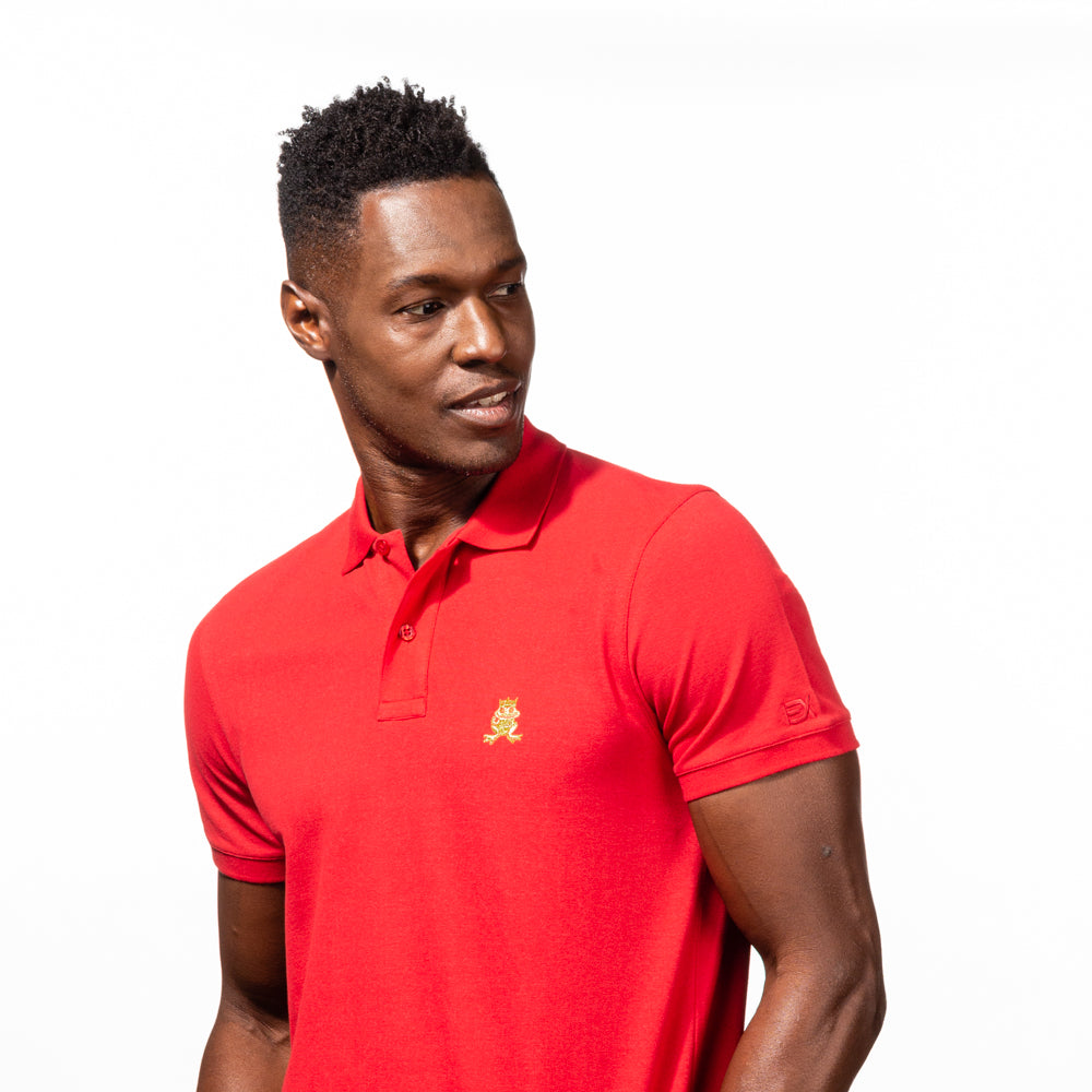 Model in red polo with two-button placket, ribbed armbands, embroidered gold frog mascot, and embroidered EX logo on left sleeve.  